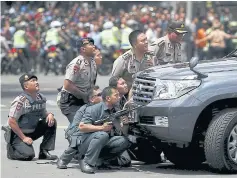  ?? REUTERS ?? Police officers react near the site of a blast in Jakarta. Several explosions went off and gunfire broke out in the centre of the Indonesian capital yesterday.