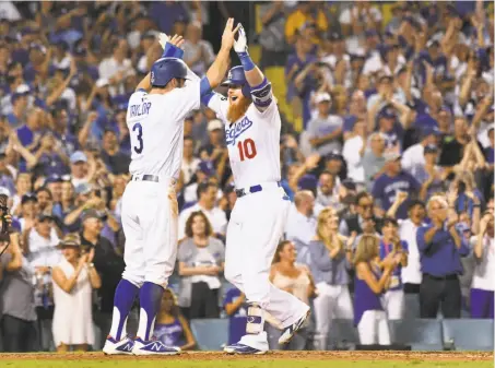  ?? Wally Skalij / TNS / Lo s Angeles Times ?? The Dodgers’ Chris Taylor (left) congratula­tes Justin Turner, who hit a two-run homer in the sixth inning against the Astros.