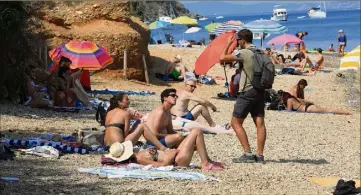  ?? (Photos Frank Muller) ?? Les gardes régionaux forestiers abordent les vacanciers sur la plage pour les informer de l’interdicti­on de fumer dans les massifs, sous peine d’une amende de  euros si le risque incendie est élevé.