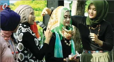  ?? ADI WIJAYA/JAWA POS ?? GRATIS: Camelia Nanda (kanan) memberikan tutorial hijab yang simpel kepada pengunjung Minggu Sehat kemarin.