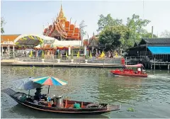  ??  ?? ABOVE A vendor paddles a boat to sell noodles. In the background is Wat Prasatsit or Wat Lak Ha.