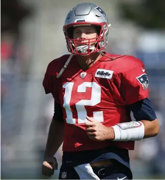  ?? NANCY LANE / BOSTON HERALD ?? LET’S GO: Tom Brady hits the field for practice yesterday in Foxboro.