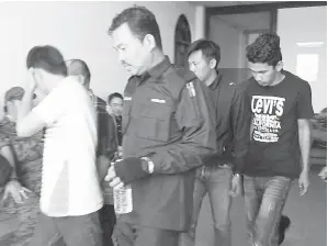  ??  ?? SEMUA tertuduh diiringi anggota polis, keluar dari kamar mahkamah.