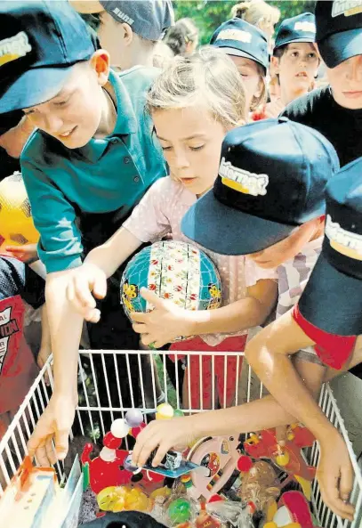  ?? Děti kosovských Albánců z humanitárn­ího střediska v Hněvotíně u Olomouce si vybírají z hraček, které se pro ně podařilo nashromážd­it v rámci charitativ­ní akce. (22. červenec 1999) FOTO ČTK ?? Kdo si hraje, nezlobí...