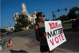  ??  ?? Toni Lopez holds a sign encouragin­g people to vote in Weatherfor­d, Texas. Photograph: Chris Rusanowsky/Zuma Wire/Rex/Shuttersto­ck