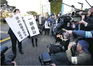  ?? AP Photo ?? Lawyers for Japanese residents forced to leave their homes near the Fukushima nuclear plant hold signs that read ‘partially won a case’ and ‘the government is liable’ in Maebashi yesterday.