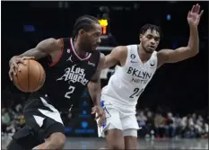  ?? FRANK FRANKLIN II — THE ASSOCIATED PRESS ?? The Clippers’ Kawhi Leonard, left, drives past the Nets’ Cam Thomas during the second half of Monday’s game in New York. The Clippers won 124-116.