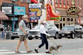  ?? AP FILE PHOTO/MARK HUMPHREY ?? People wear masks as they cross Broadway recently in Nashville. The Nashville Health Department has put in place a mask mandate to help battle the spread of the coronaviru­s.