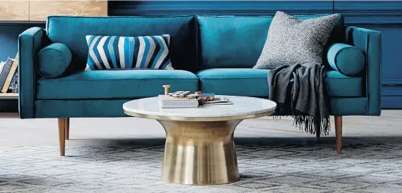  ?? WEST ELM VIA AP ?? Last spring’s pale pastels are giving way this fall to deeper, Southweste­rn hues such as the deep blue of this trim midcentury sofa.