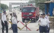  ?? B.K. BANGASH/ THE ASSOCIATED PRESS ?? Police officers make way for a fire truck at the Minhas air force base in Kamra on Thursday after a gun battle with militants. Eight attackers and one security official were killed.