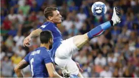  ??  ?? UDINE: Italy’s forward Andrea Belotti (R) is watched by teammate Antonio Candreva as he leaps for the ball during the FIFA WC 2018 football qualificat­ion match between Italy and Liechtenst­ein at The Dacia Arena Stadium in Udine on Sunday. — AFP