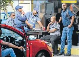  ??  ?? BADLY SHAKEN: Police talk to security guards at the scene of the robbery at the Sasol filling station in Linton Grange