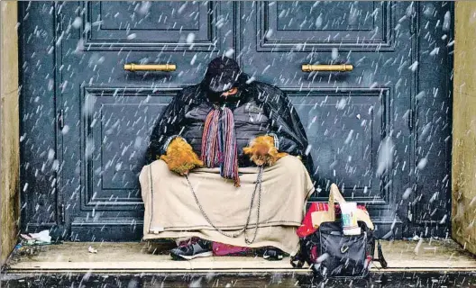  ?? GERARD JULIEN / AFP ?? ‘Clochards’.Un sintecho duerme con sus perros en un portal del aristocrát­ico bulevar Haussmann de París, Abajo, la alcaldesa Hidalgo