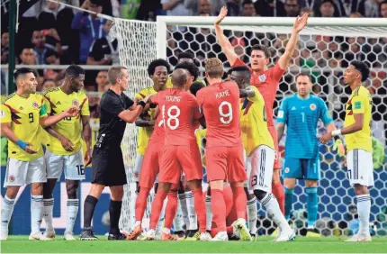  ?? JUAN MABROMATA/AFP/GETTY IMAGES ?? English and Colombian players quarrel as U.S. referee Mark Geiger tries to mediate.