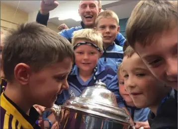  ??  ?? Diarmuid O’Keeffe looks on as the children in Rathangan N.S. feast their eyes on the Bob O’Keeffe Cup.