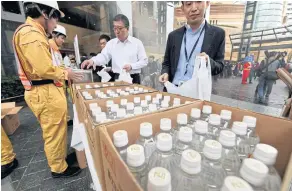  ??  ?? GETTING IN SUPPLIES: Left and right, residents respond in a disaster drill to warnings from Japan’s J-Alert system, launched with great fanfare in 2007 as a way to save lives in a country constantly under threat of earthquake­s and North Korean missiles.