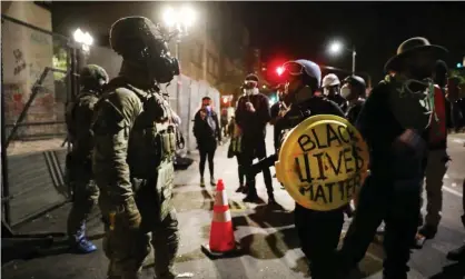  ??  ?? Federal police confront protesters in downtown Portland, Oregon. Photograph: Spencer Platt/Getty Images