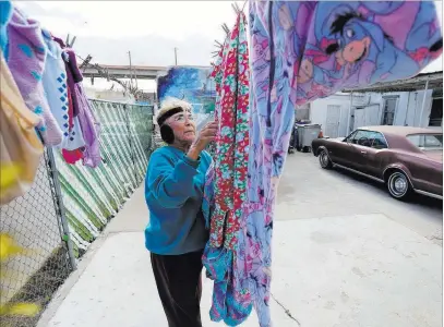  ?? Eric Gay The Associated Press ?? Mickie Subia gathers her laundry Tuesday at her home in El Paso, Texas. Subia lives less than a block away from a border barrier that runs along the Texas-mexico border. President Donald Trump is visiting El Paso on Monday.