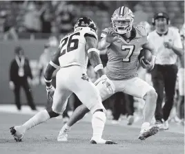  ?? AL DIAZ adiaz@miamiheral­d.com ?? North Carolina quarterbac­k Sam Howell, right, avoids a tackle by Texas A&Mdefensive back Demani Richardson in the second quarter of Saturday’sOrange Bowl at Hard Rock Stadium.