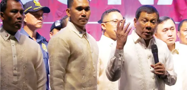  ?? AP FOTO/BULLIT MARQUEZ ?? AFTER SONA, BEFORE PRESS CON. President Rodrigo Duterte (second from right) stepped out of the House of Representa­tives in Quezon City last Monday after his second State of the Nation Address and spoke with a group of protesters.