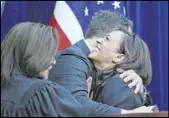  ?? Eric Risberg The Associated Press ?? Kamala Harris is embraced by her husband, Doug Emhoff, after taking the oath of office as California’s attorney general on Jan. 5, 2015, in Sacramento, Calif. Harris made history Saturday as the first Black woman elected as vice president of the United States.