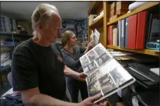  ?? PHOTOS BY JOSH STEPHENSON — SPECIAL TO THE DENVER POST ?? Jim Carver goes through some photos and slides taken during the building of Carver Brewing Co. with current brewpub owner/operator Claire Carver.