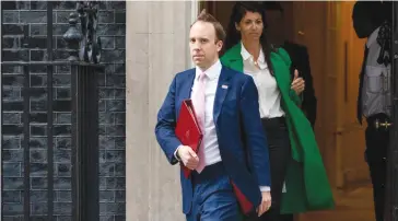  ?? FOTO: GETTY ?? Matt Hancock și asistenta lui Gina Coladangel­o părăsind numărul 10 din Downing Street luna trecută.