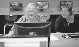  ?? ASSOCIATED PRESS] [NATI HARNIK/THE ?? Cheryl Bast, left, is accompanie­d by her daughter Liz Pierson, as she works on an applicatio­n for a position with Omaha Public Schools, during a job fair held at Omaha South High School in Omaha, Neb. Friday’s government report on jobs shows...