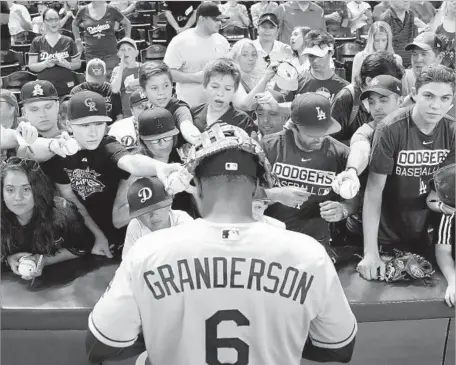  ?? Christian Petersen Getty Images ?? CURTIS GRANDERSON of the Dodgers signs autographs for fans before the game against the Arizona Diamondbac­ks on Aug. 29 at Chase Field in Phoenix. In what has been a roller-coaster year, the team’s fans are hoping another postseason doesn’t end in...