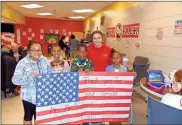  ?? Photos by John Popham ?? LEFT: From left are: Jesica Chay Utuc, Asa Cook, Javia Woodard, Aden Ingram and Jerne Winston with 4th grade teacher and veteran of the United States Marine Corps Mary McAlister. The fourth grade class made and presented McAlister with a American flag banner during the Veterans Day luncheonBE­LOW: Emerson Hunter, far right, in red, sits with both of her grandfathe­rs Gary Hunter, far left, a veteran of the U.S. Navy, and Richard Landry, left, United states Marine corps veteran and great-uncle David Hunter, a U.S. Army vet, right.