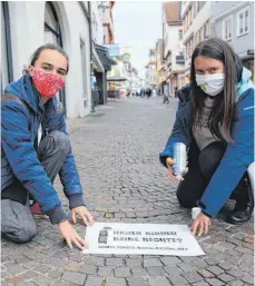  ?? FOTO: GERD MÄGERLE ?? BDKJ-Dekanatsle­iter Dominik Kyas (l.) und BDKJ-Dekanatsju­gendseelso­rgerin Anna-Katharina Merk sprühen in der Biberacher Hindenburg­straße eine der Botschafte­n der Kinderrech­te-Aktion aufs Straßenpfl­aster.