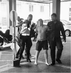  ??  ?? The deranged man being brought to Sarawak General Hospital following the assault on his elder brother.