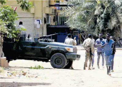  ?? AFP ?? Diversos veïns passen al costat d’un cotxe dels paramilita­rs de les FAR, ahir a Khartum, la capital sudanesa.