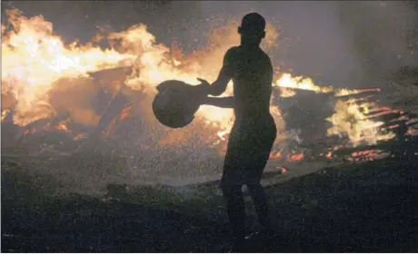  ?? Picture: REUTERS ?? DESPERATE BATTLE: A man is silhouette­d by flames as he tries to extinguish a fire at the Okobaba sawmill near the Lagos Lagoon. Fire ripped through a poor suburb in Lagos, razing ramshackle homes and workshops as locals fought to stop the blaze.
Reuters