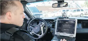  ?? TROY FLEECE ?? Regina Police Service Const. Eric Lauf demonstrat­es the HealthIM app. The pilot project software is in every police cruiser and is linked to Regina General Hospital. Saskatoon police are also using the app.