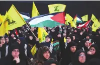  ?? (Mohamed Azakir/Reuter) ?? SUPPORTERS WAVE FLAGS as they wait for Hezbollah leader Hassan Nasrallah to speak, in Beirut last week.