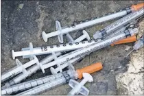  ??  ?? Discarded syringes are seen in 2017 in an open-air heroin market along train tracks outside the heart of Philadelph­ia. Oklahoma legislator­s are looking at the possibilit­y of legalizing open needle exchanges in an effort to stop the spread of disease, so drug users won't have to share used needles. [AP FILE PHOTO]