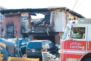  ?? RICH ROLEN/SPECIAL TO THE MORNING CALL ?? Crews survey the damage on Saturday after an apparent explosion and fire at a house on the 100 block of Ann Street in Easton early in the morning.