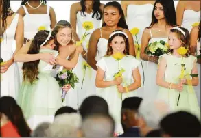  ?? Christian Abraham / Hearst Connecticu­t Media ?? Fourth grade flower girl Grayson Fels, left, gets a hug from graduate Avery Sammons after they exchange flowers during Greenwich Academy's 195th Commenceme­nt in Greenwich on Thursday. Broadcast journalist Amna Nawaz, currently PBS NewsHour's chief correspond­ent, delivered the graduation address.