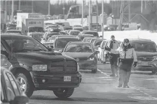  ?? WAYNE CUDDINGTON/ POSTMEDIA ?? Police direct traffic at Carling and Kirkwood avenues amid the chaos created by an early morning accident on the Queensway that resulted in the death of a 50-year-old Carleton Place man.