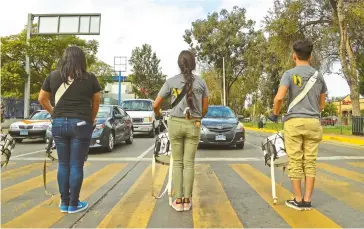  ??  ?? LOS JÓVENES aprovechan cada luz roja del semáforo para tocar por algunos minutos.