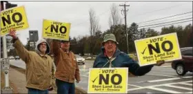  ??  ?? Residents hold signs urging voters to vote “no” on the land sale.