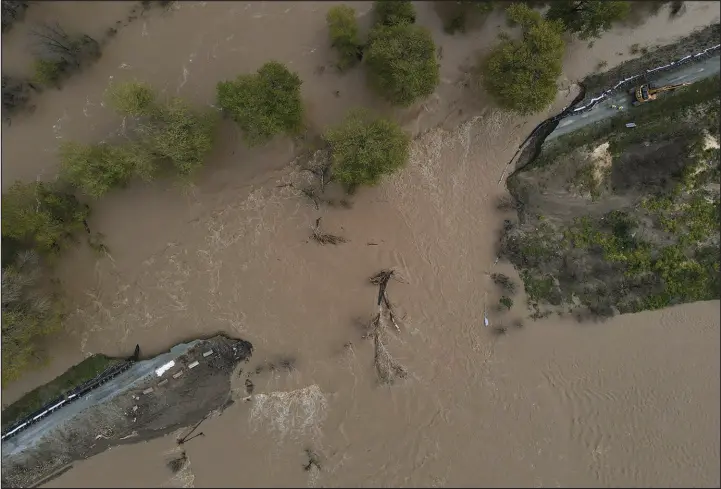  ?? SHMUEL THALER / THE SANTA CRUZ SENTINEL VIA AP ?? The Pajaro River waters flow into Monterey County fields Sunday in Pajaro Valley, Calif., after the river levee breached early Saturday.