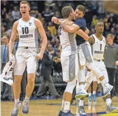  ?? ASSOCIATED PRESS ?? Marquette’s Sam Hauser (left) and Matt Heldt (center) celebrate the win.