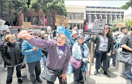  ?? RAY CHAVEZ — STAFF PHOTOGRAPH­ER ?? Anna Marie Stenberg, center, and demonstrat­ors chant during a protest outside the U.S. Immigratio­n and Customs Enforcemen­t office in San Francisco on Tuesday. The protest was in response to the Trump administra­tion’s policy that separates migrant children from parents detained at the border.