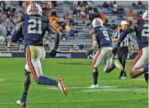  ?? TODD VAN EMST/AU ATHLETICS ?? Auburn safety Smoke Monday receives a defensive escort on his way to a 100-yard intercepti­on return for a touchdown during last Saturday night’s 30-17 win over Tennessee.