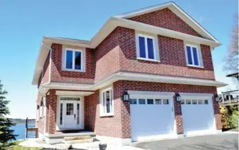  ?? COLDWELL BANKER R.M.R. REAL ESTATE PHOTOS ?? This two-storey detached brick home comes with an attached heated double-car garage and a long driveway.