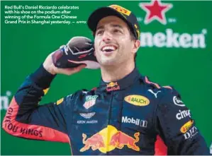  ?? AFPPIX ?? Red Bull’s Daniel Ricciardo celebrates with his shoe on the podium after winning of the Formula One Chinese Grand Prix in Shanghai yesterday. – CHINESE F1 GRAND PRIX