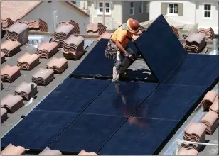  ?? PHOTO BY WILL LESTER — THE PRESS-ENTERPRISE/SCNG ?? Workers install solar panels on the roofs of homes under constructi­on south of Corona on May 3, 2018.