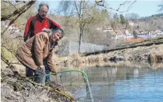  ?? FOTO: HEINZ THUMM ?? Die Naturschüt­zer Anette Bürkle und Reinhold Braun füllten das Biotop mit Bachwasser auf.
